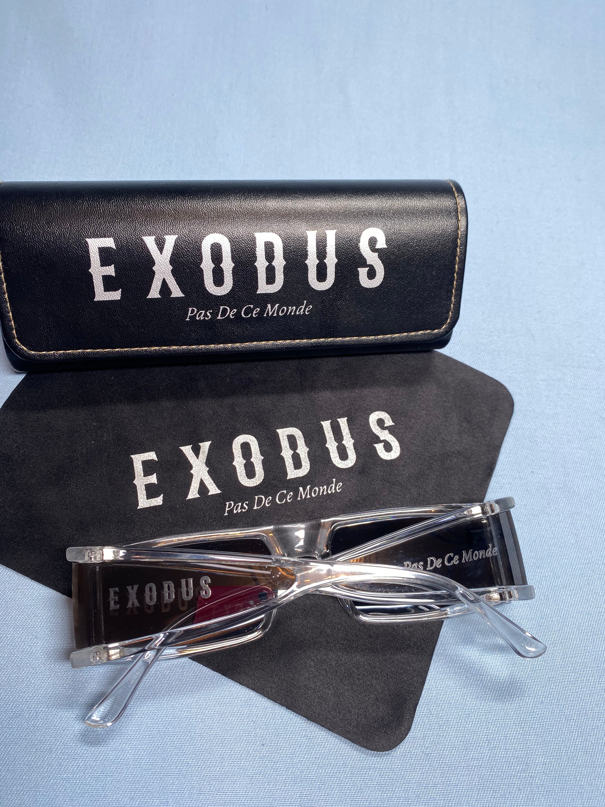 Clothing and accessories from Exodus Pas De Ce Monde – unisex streetwear including t-shirts, jackets, sunglasses, jewelry, bags, and headwear designed for everyday wear and bold urban fashion.