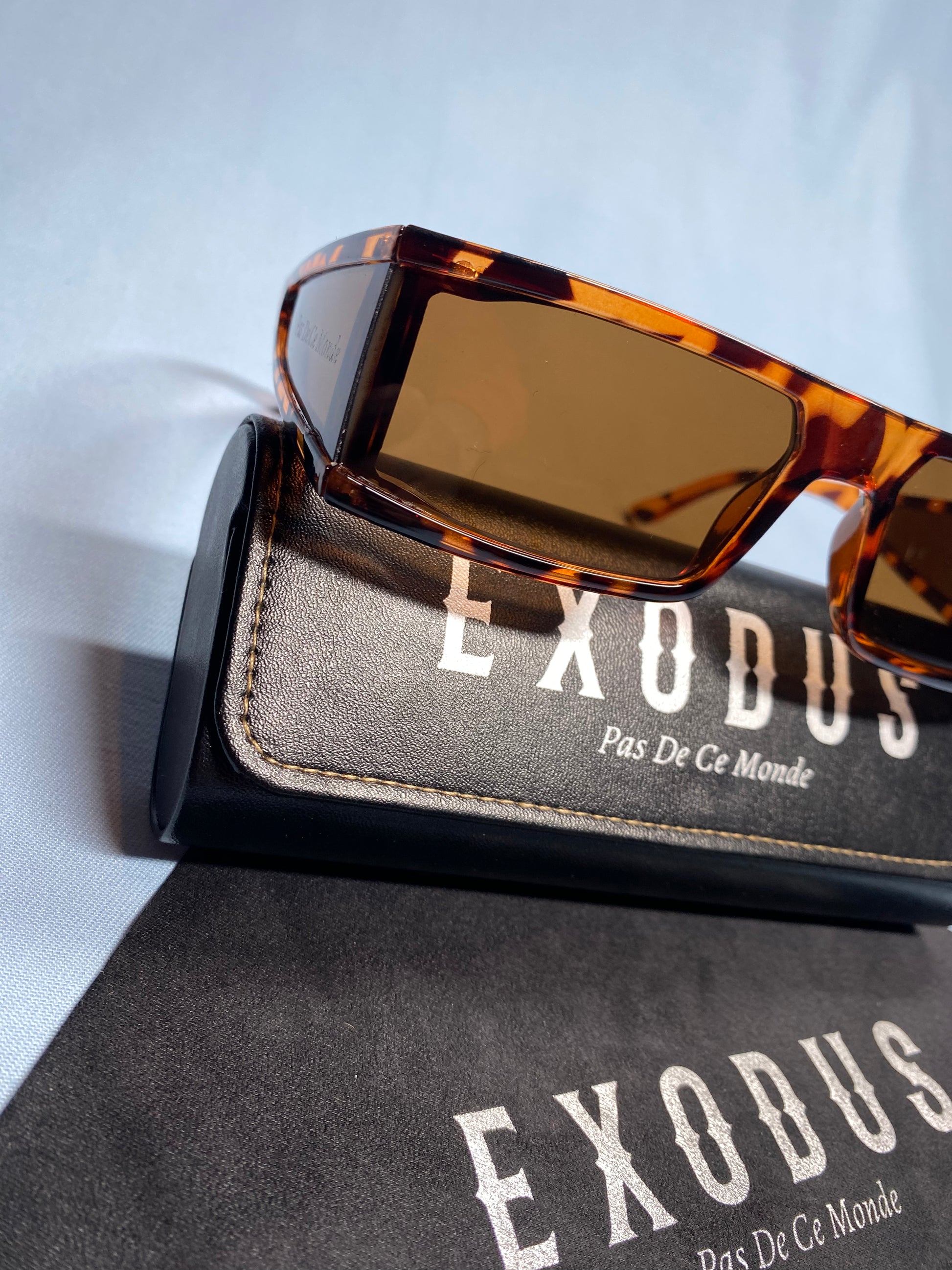Clothing and accessories from Exodus Pas De Ce Monde – unisex streetwear including t-shirts, jackets, sunglasses, jewelry, bags, and headwear designed for everyday wear and bold urban fashion.