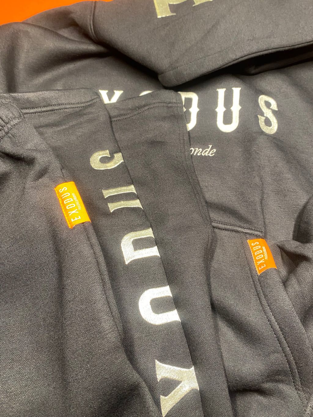 Clothing and accessories from Exodus Pas De Ce Monde – unisex streetwear including t-shirts, jackets, sunglasses, jewelry, bags, and headwear designed for everyday wear and bold urban fashion.
