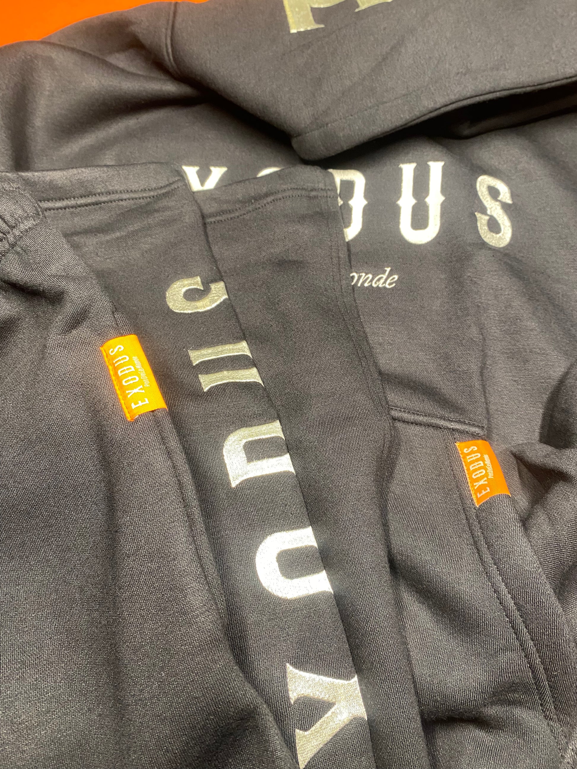 Clothing and accessories from Exodus Pas De Ce Monde – unisex streetwear including t-shirts, jackets, sunglasses, jewelry, bags, and headwear designed for everyday wear and bold urban fashion.
